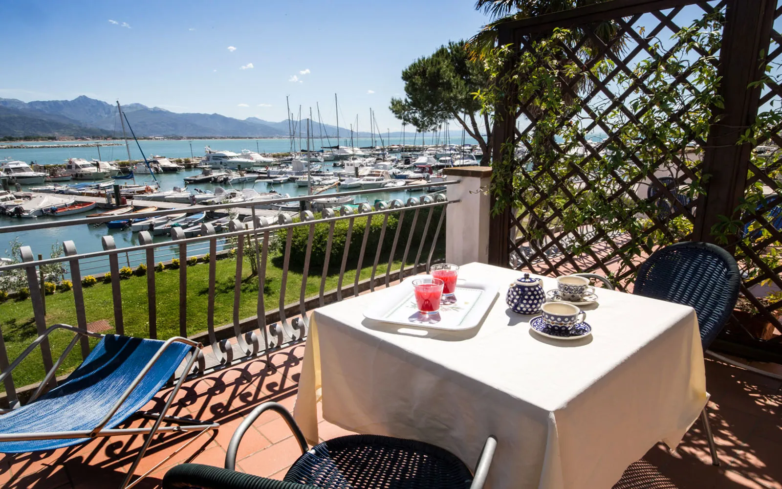 Terrazza con tavolo per la colazione e vista panoramica sul porto e le montagne