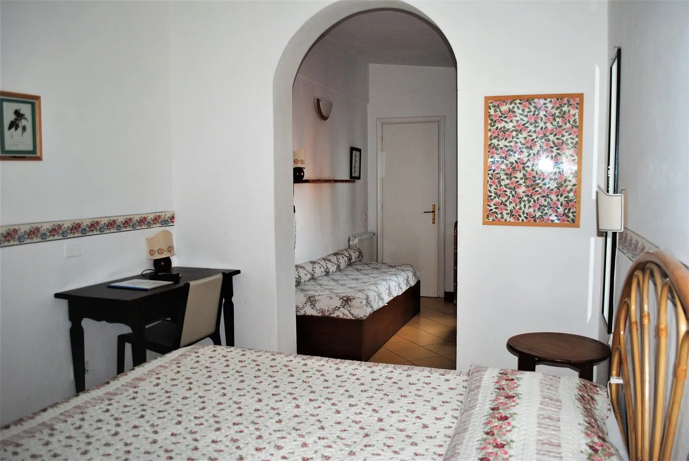 Camera con letto matrimoniale, scrivania e zona con letto singolo aggiuntivo
