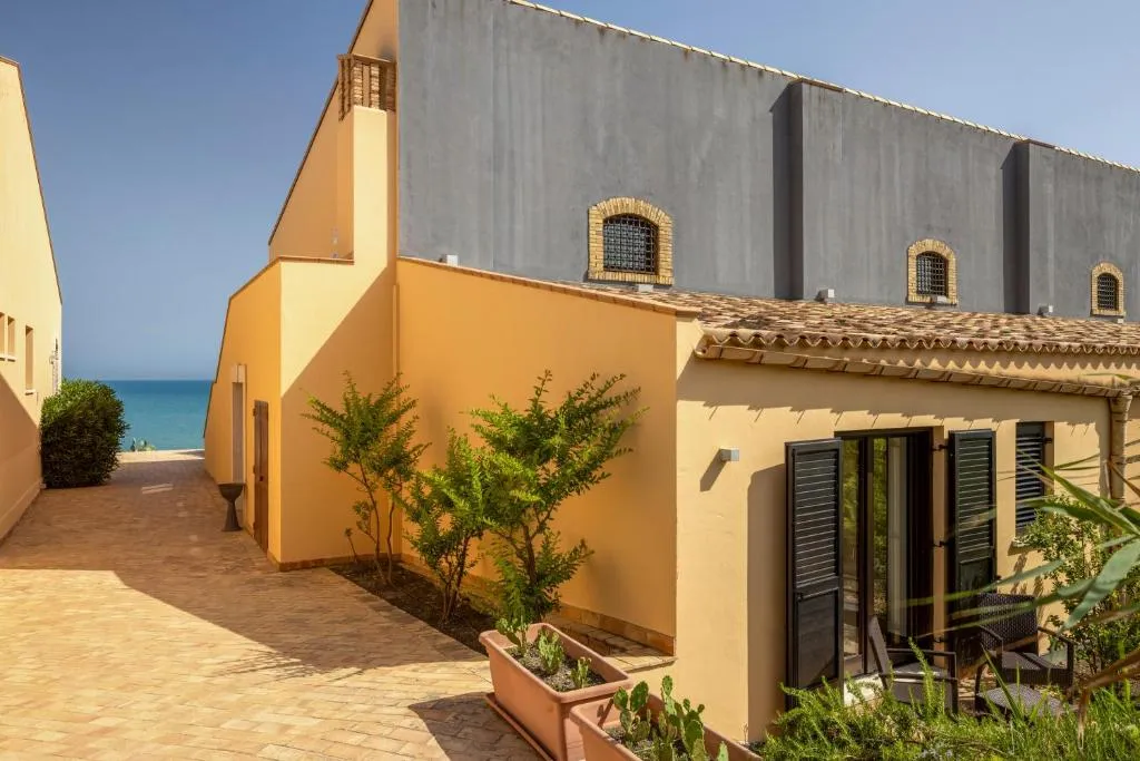 Vialetto esterno tra gli edifici in tono ocra con vista sul mare