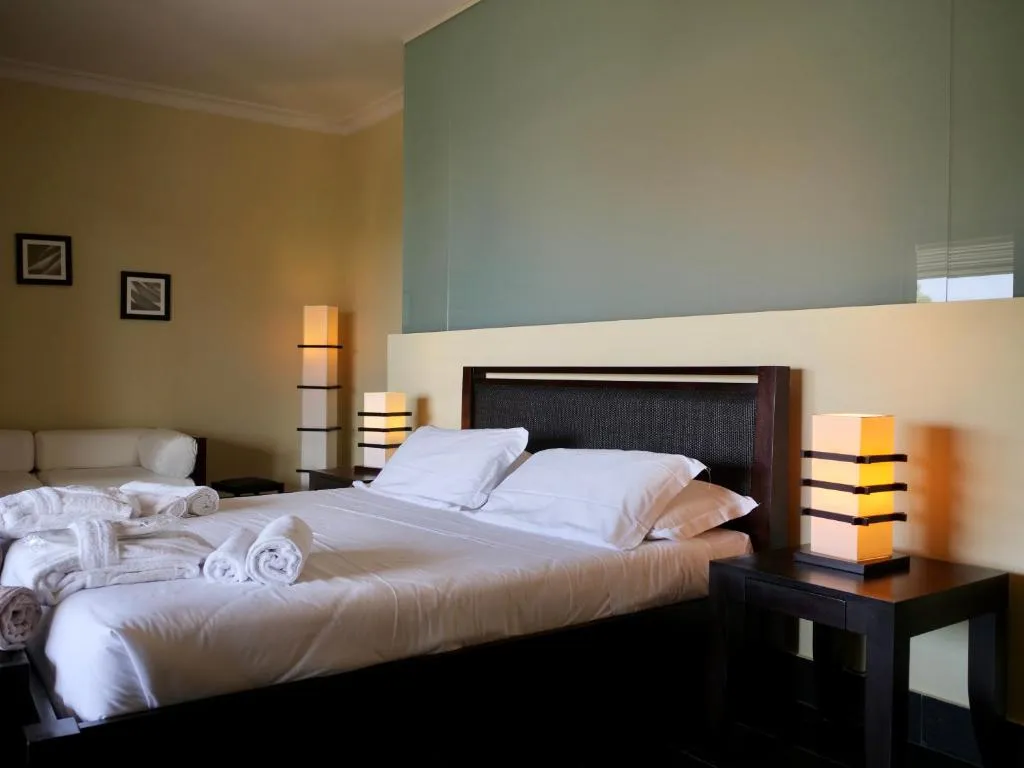Camera moderna con letto matrimoniale, lampade da comodino e tonalità calde