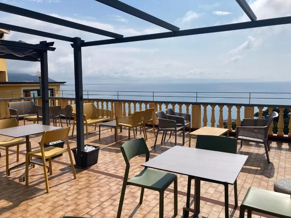 Terrazza panoramica con pergolato, tavoli e sedie affacciata sul mare