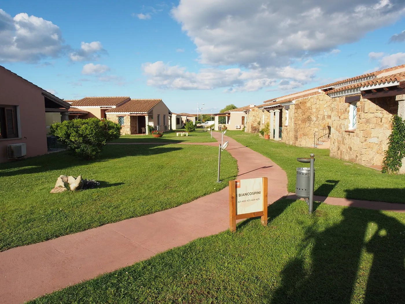 Viale del villaggio tra le casette in pietra con prato verde