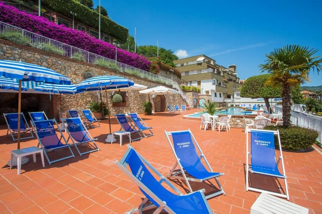 Terrazza solarium con lettini e ombrelloni blu e bougainville fiorita