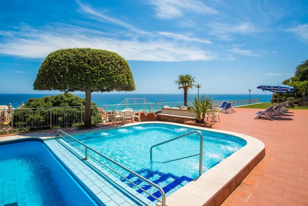 Piscina con idromassaggio, albero decorativo e vista sul mare