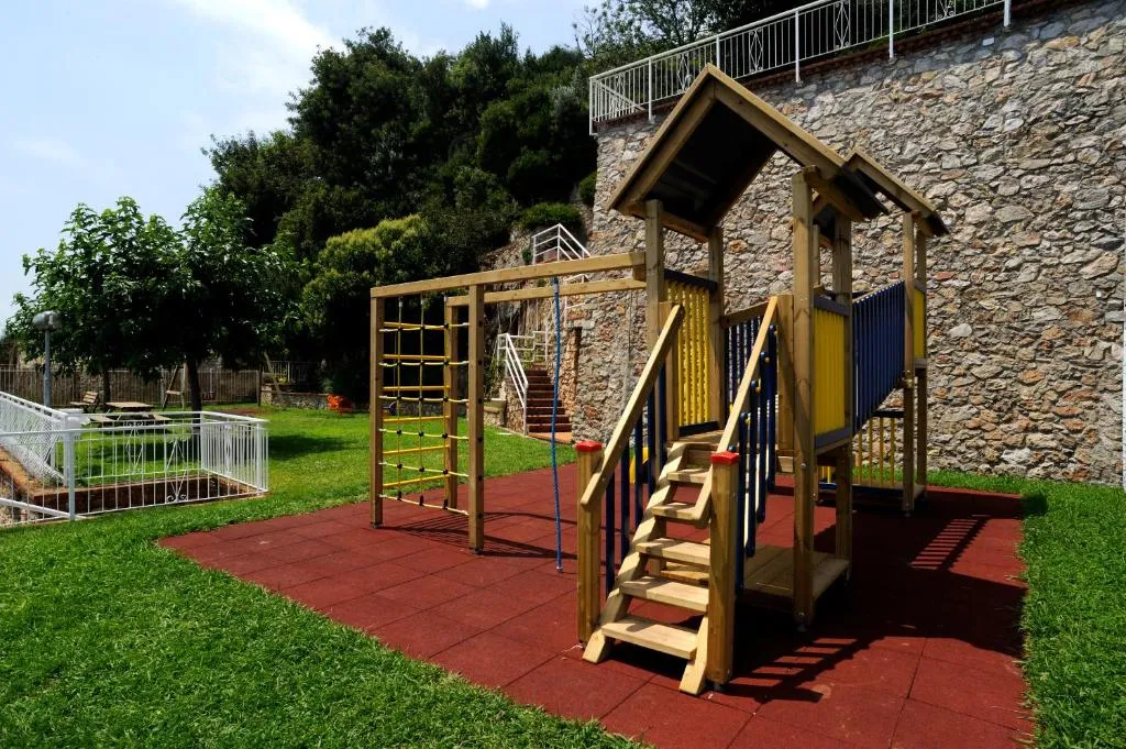 Parco giochi in legno per bambini con scivolo e arrampicata nel giardino