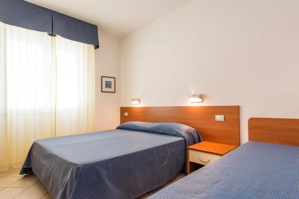 Camera con letto matrimoniale e letto singolo, arredo in legno
