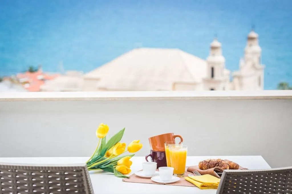 Colazione in terrazza con cornetti, succo e vista mare e campanili