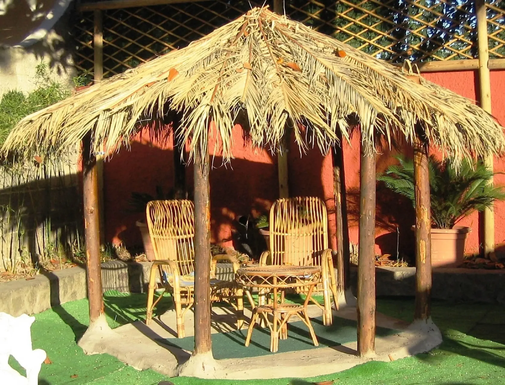 Gazebo in paglia con sedie in vimini nel giardino dell'hotel