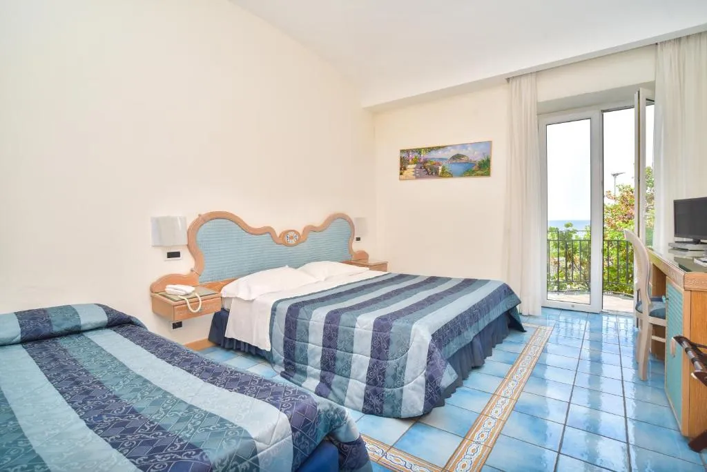 Camera tripla con due letti, scrivania e balcone vista mare