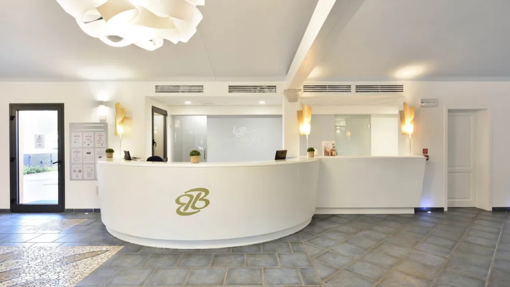 Reception del resort con bancone bianco curvo e lampadario di design