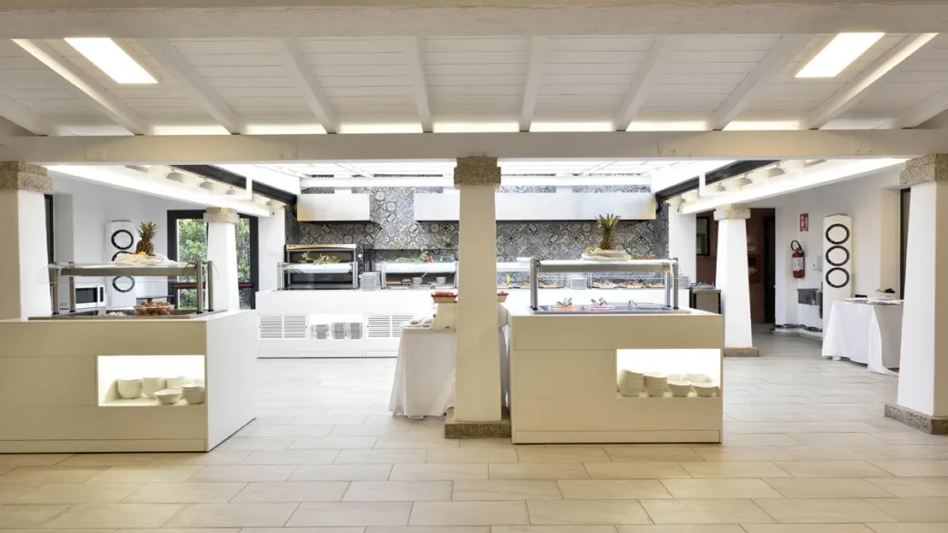 Sala buffet con banchi self-service e dispenser di piatti