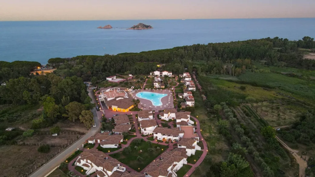 Veduta aerea al tramonto del resort con piscina e mare sullo sfondo