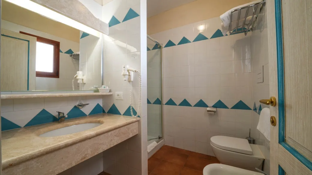Bagno della camera con doccia, lavabo in marmo e decorazioni azzurre