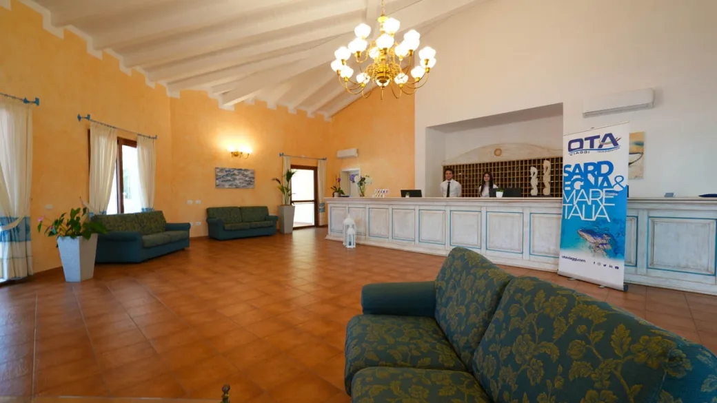 Hall del resort con divani, lampadario e reception sullo sfondo