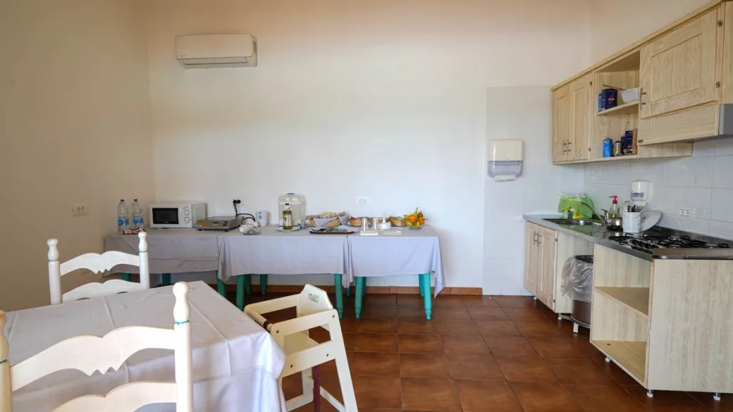 Cucina comune con angolo cottura e tavolo per la colazione