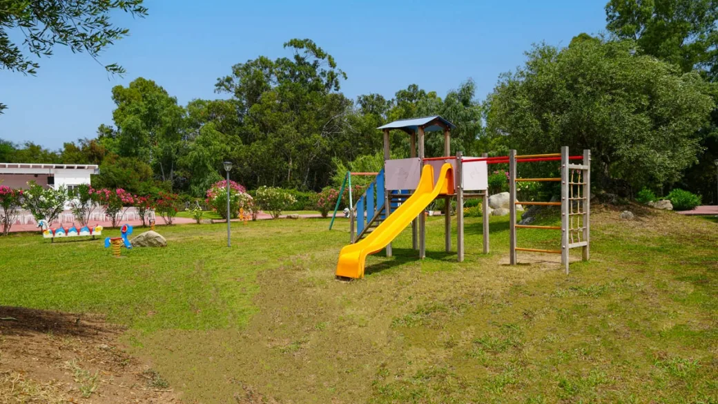 Parco giochi per bambini con scivolo immerso nel verde