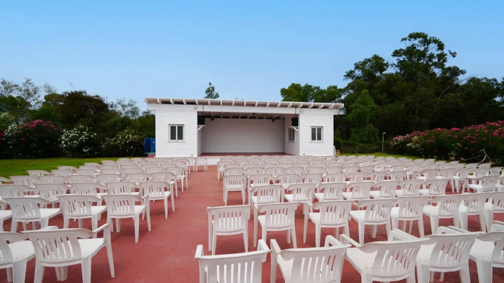 Anfiteatro all'aperto con palco e sedie bianche per spettacoli