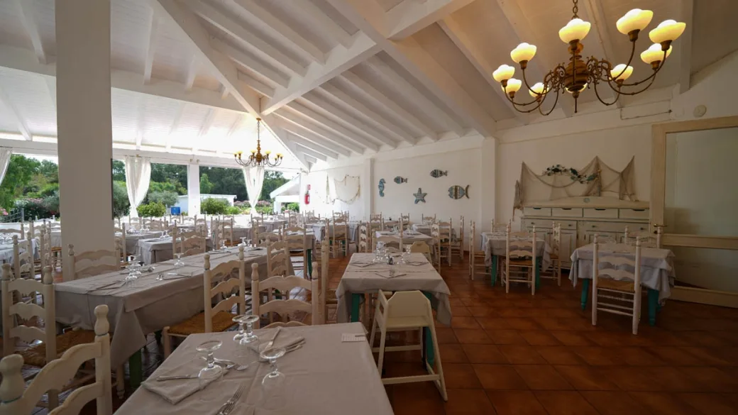 Sala ristorante interna con soffitto in legno e decorazioni marine