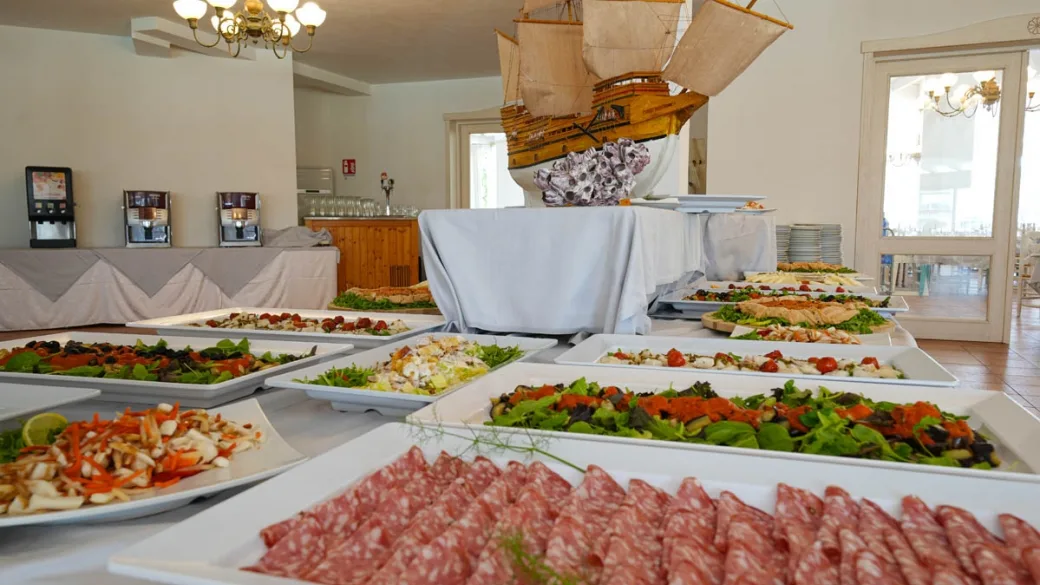 Buffet di antipasti e salumi con veliero decorativo nella sala