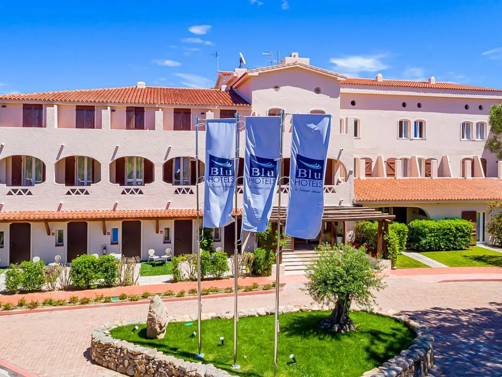 Ingresso dell'hotel con bandiere Blu Hotels e giardino