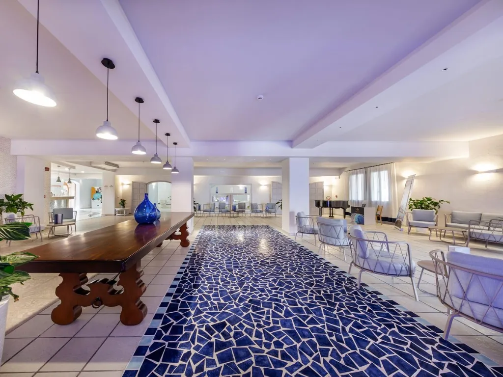 Ampia hall dell'hotel con tavolo in legno e zona salotto