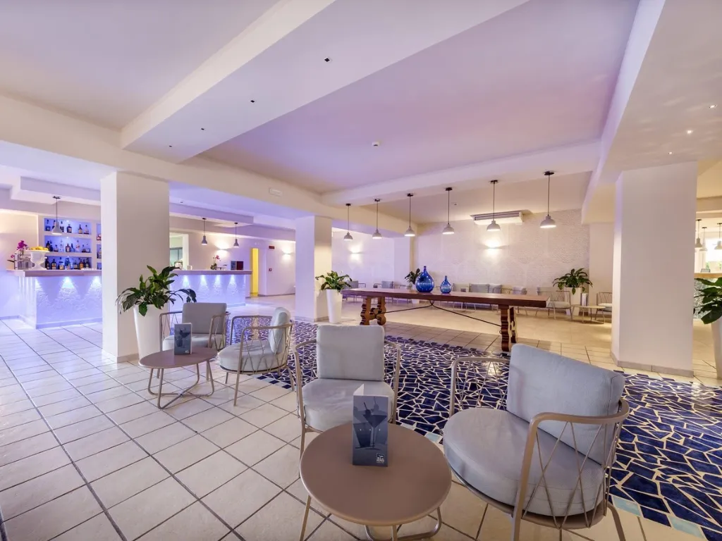 Lounge dell'hotel con poltrone, bar e mosaico blu