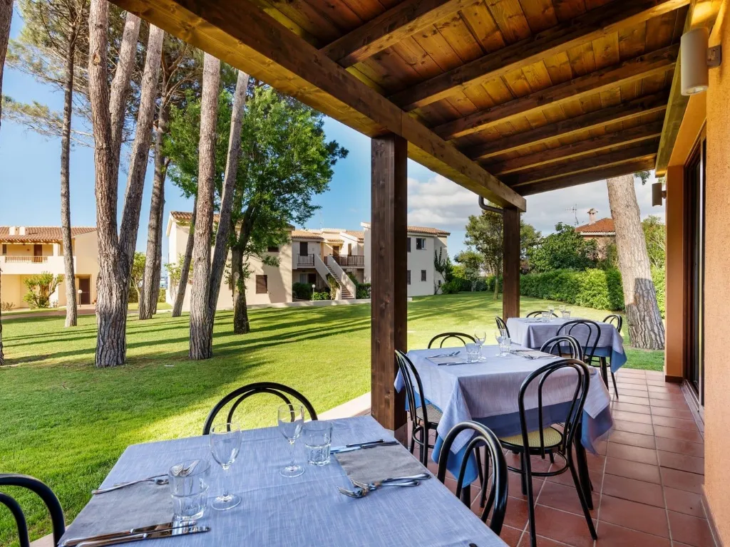 Terrazza ristorante coperta con tavoli e vista sul giardino