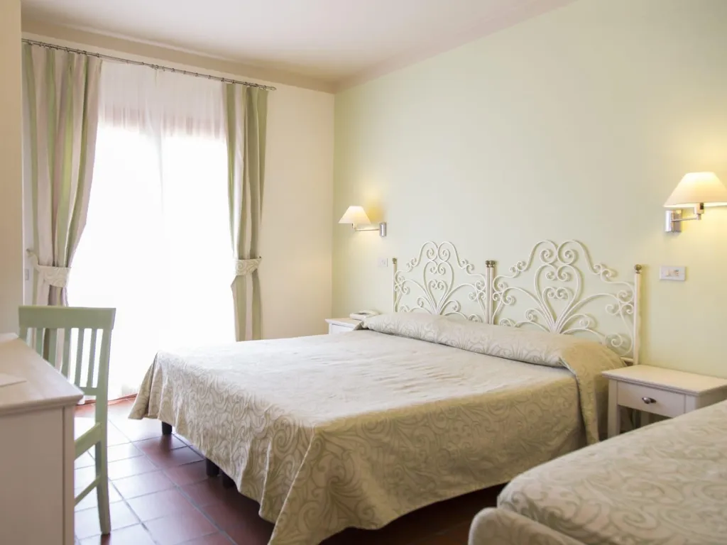 Camera con letto matrimoniale, letto singolo e testiera decorata