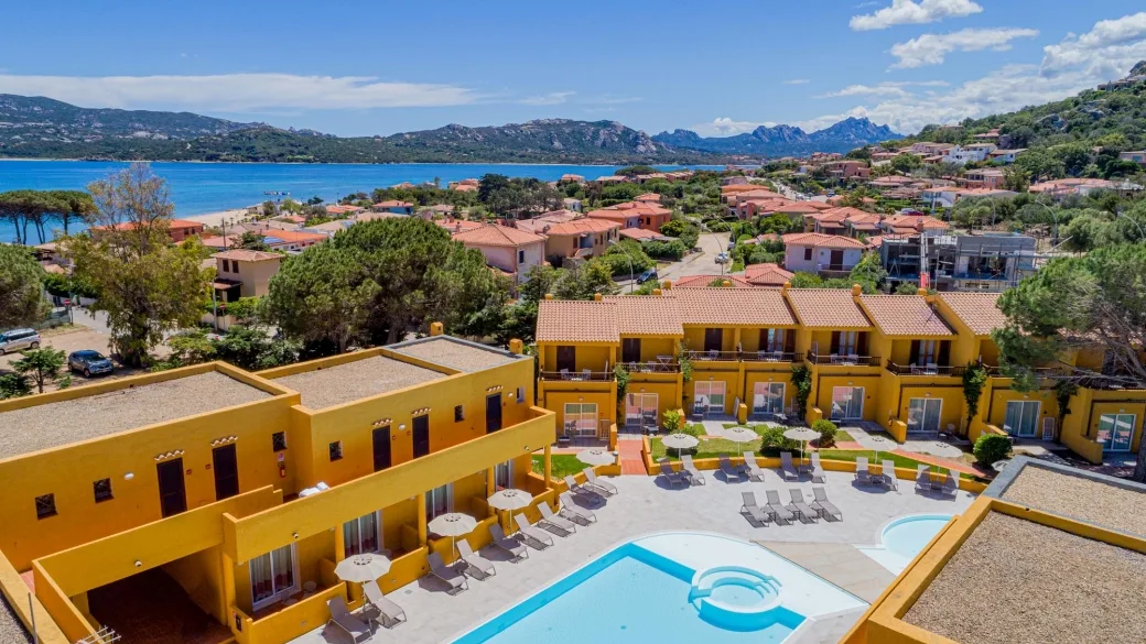 Vista aerea del resort con piscina, giardino e mare in lontananza