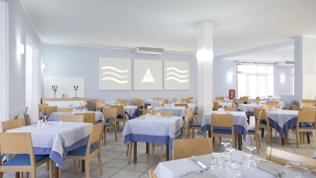 Sala da pranzo luminosa con tavoli e decorazioni a parete