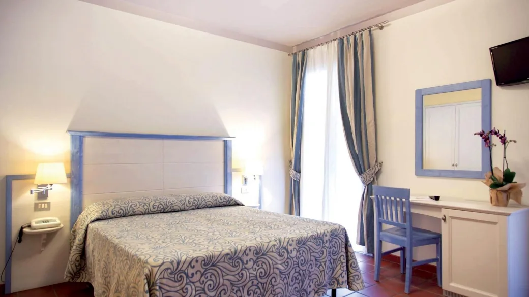 Camera matrimoniale con dettagli azzurri e scrivania