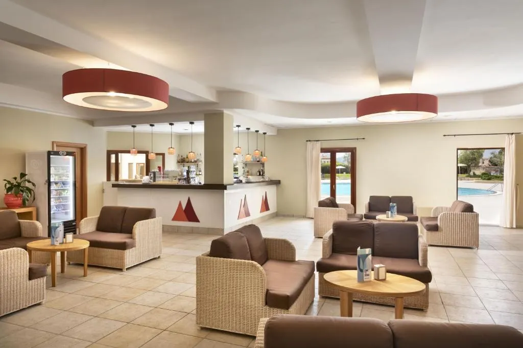Lounge con poltrone in vimini e bancone bar con vista sulla piscina