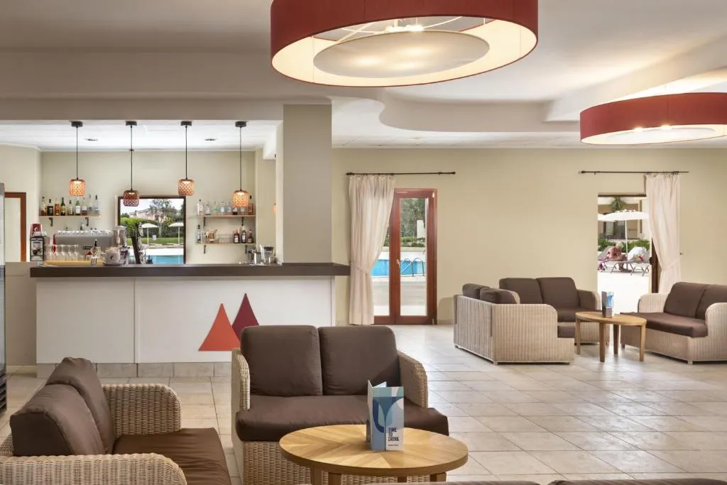 Area bar con divani in vimini, tavolini e bancone illuminato