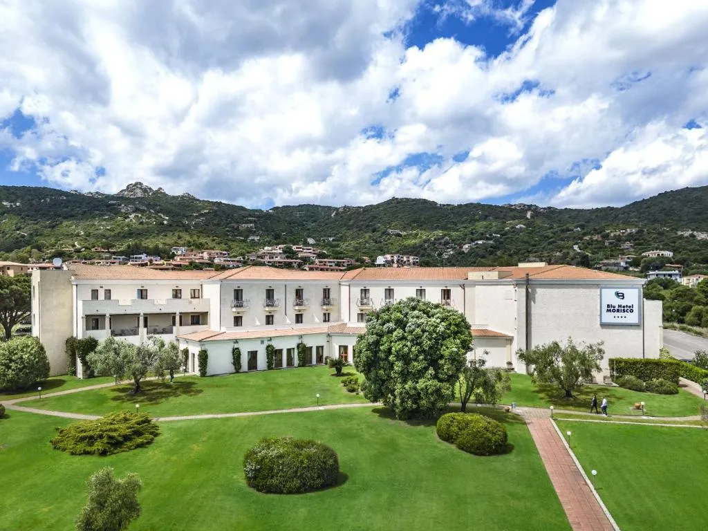 Esterno del Blu Hotel Morisco con giardino verde e colline alle spalle