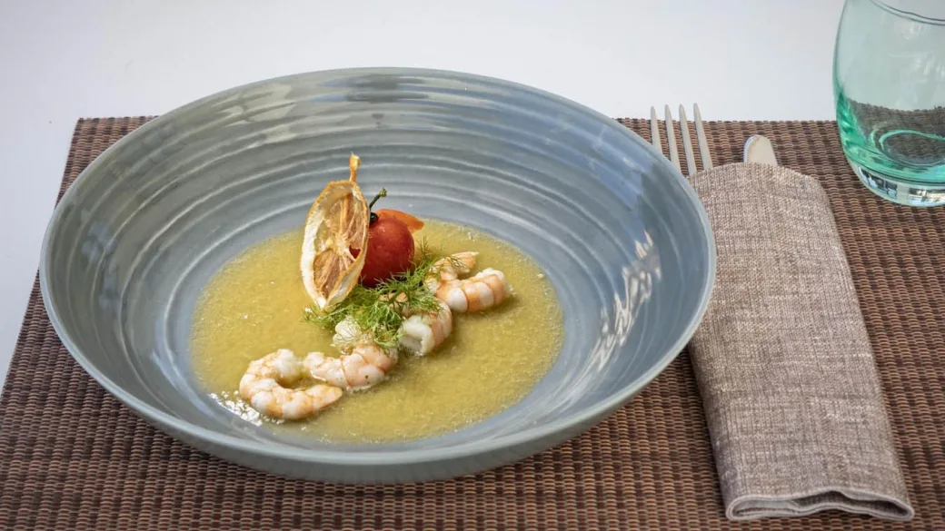 Piatto gourmet di gamberi con salsa e guarnizione su piatto grigio