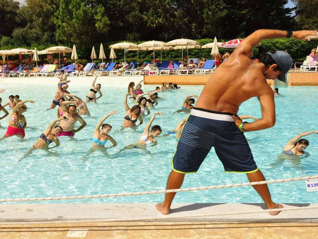 Lezione di acquagym in piscina con istruttore e ospiti