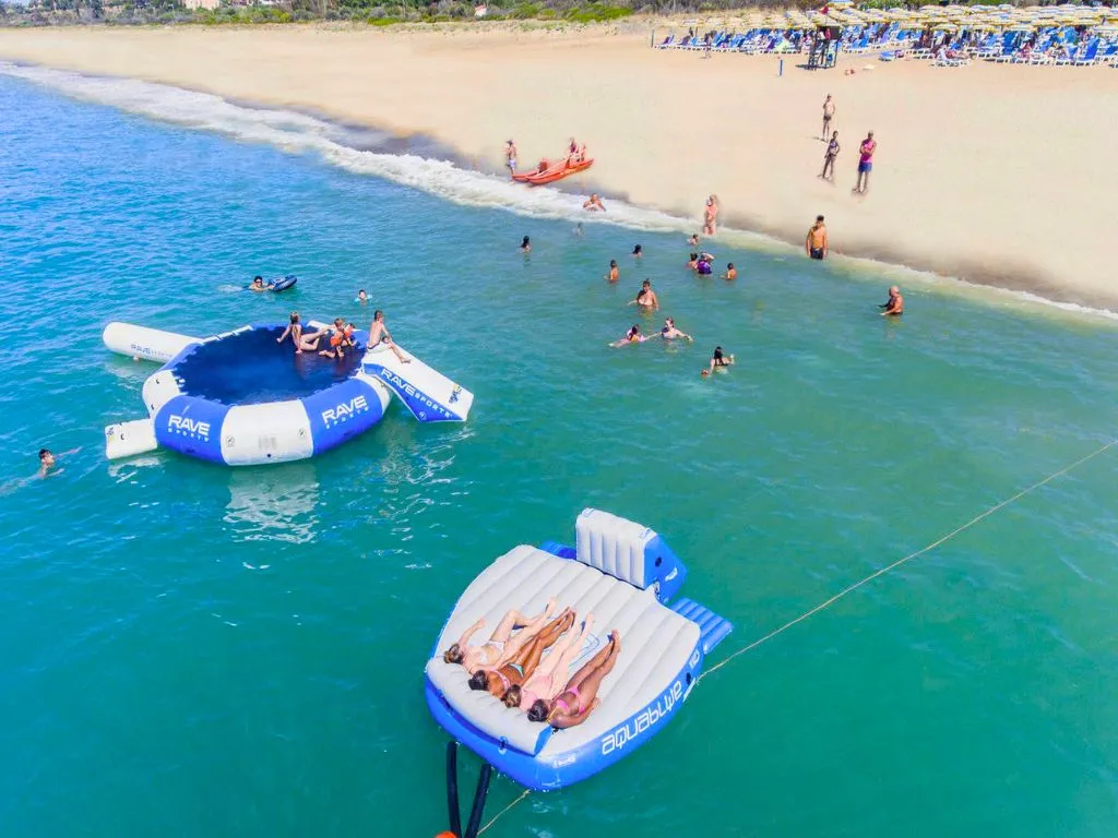 Giochi gonfiabili in mare davanti alla spiaggia con bagnanti