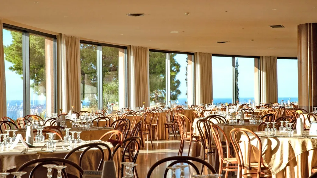 Sala ristorante interna con grandi vetrate e vista sul mare