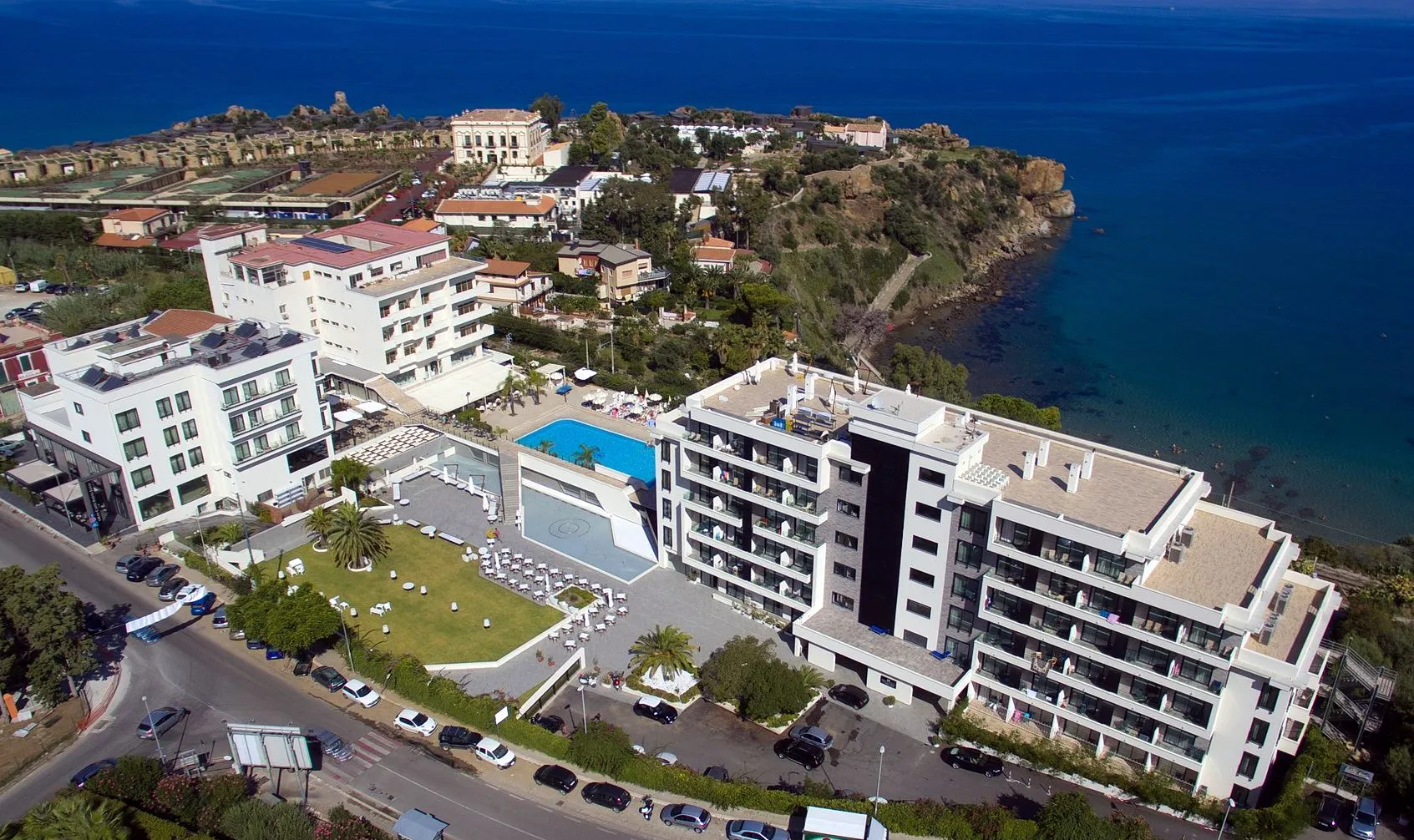 Vista aerea del complesso alberghiero affacciato sulla costa con piscina e giardino