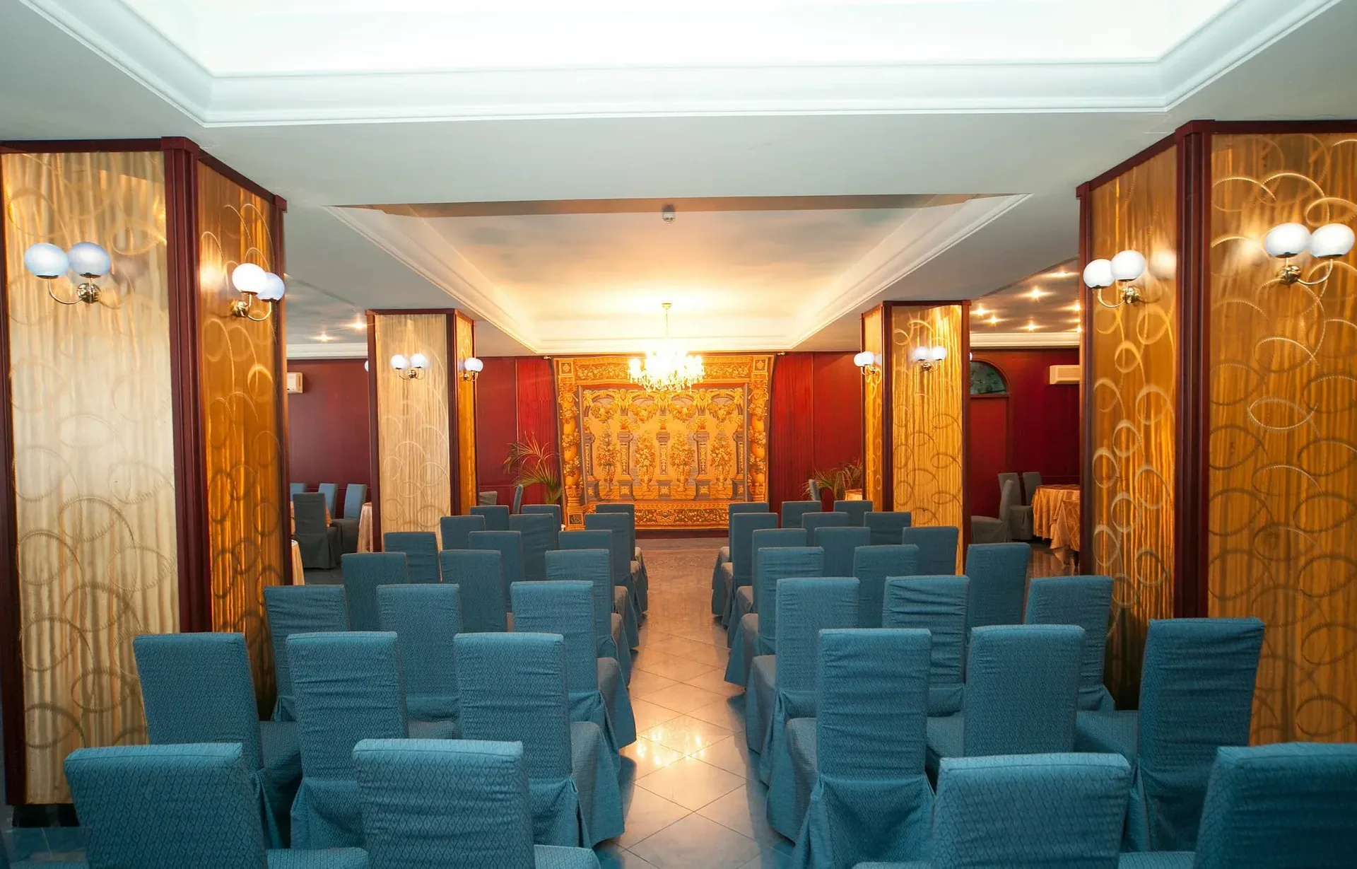 Sala interna allestita con sedie blu e pareti decorate in stile elegante per eventi