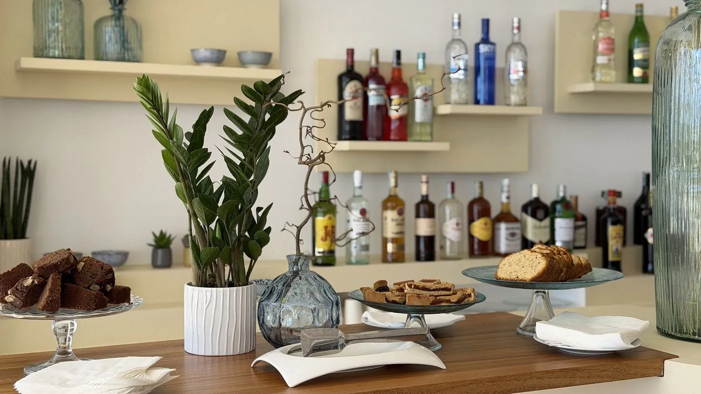 Bancone bar con dolci, torte e bottiglie di liquori su mensole
