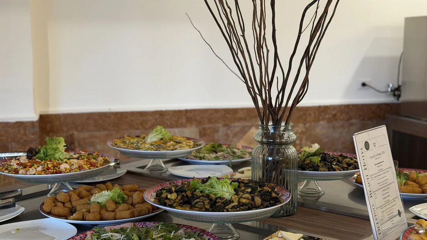 Buffet con piatti di antipasti, verdure e insalate su alzate decorate