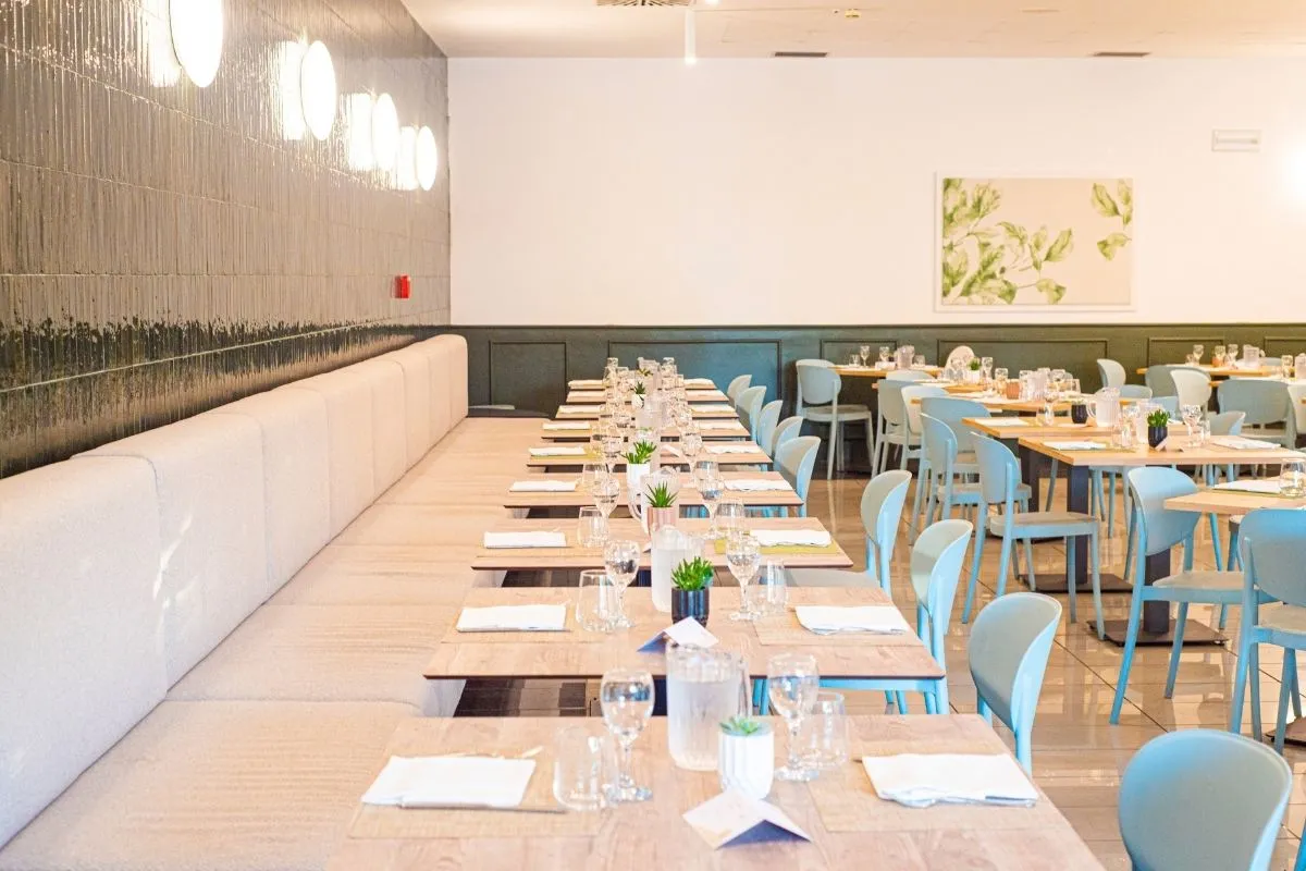 Sala ristorante moderna con tavoli in legno e sedie azzurre