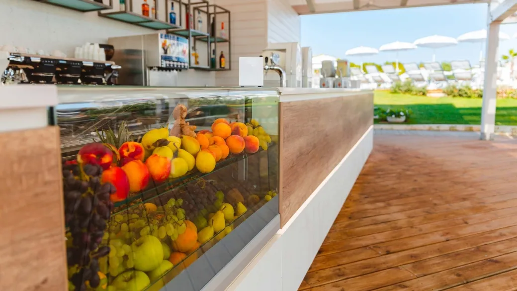 Bancone bar con frutta fresca in esposizione e vista sul solarium