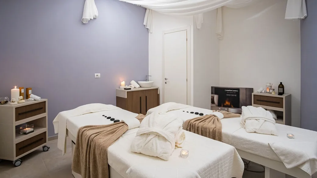 Sala massaggi della spa con lettini, accappatoi e candele