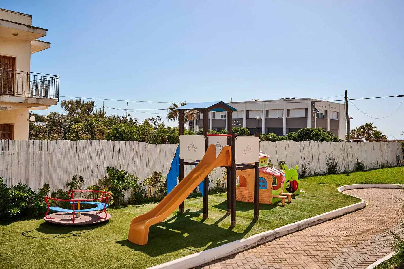 Area giochi per bambini con scivolo e giostrina nel giardino