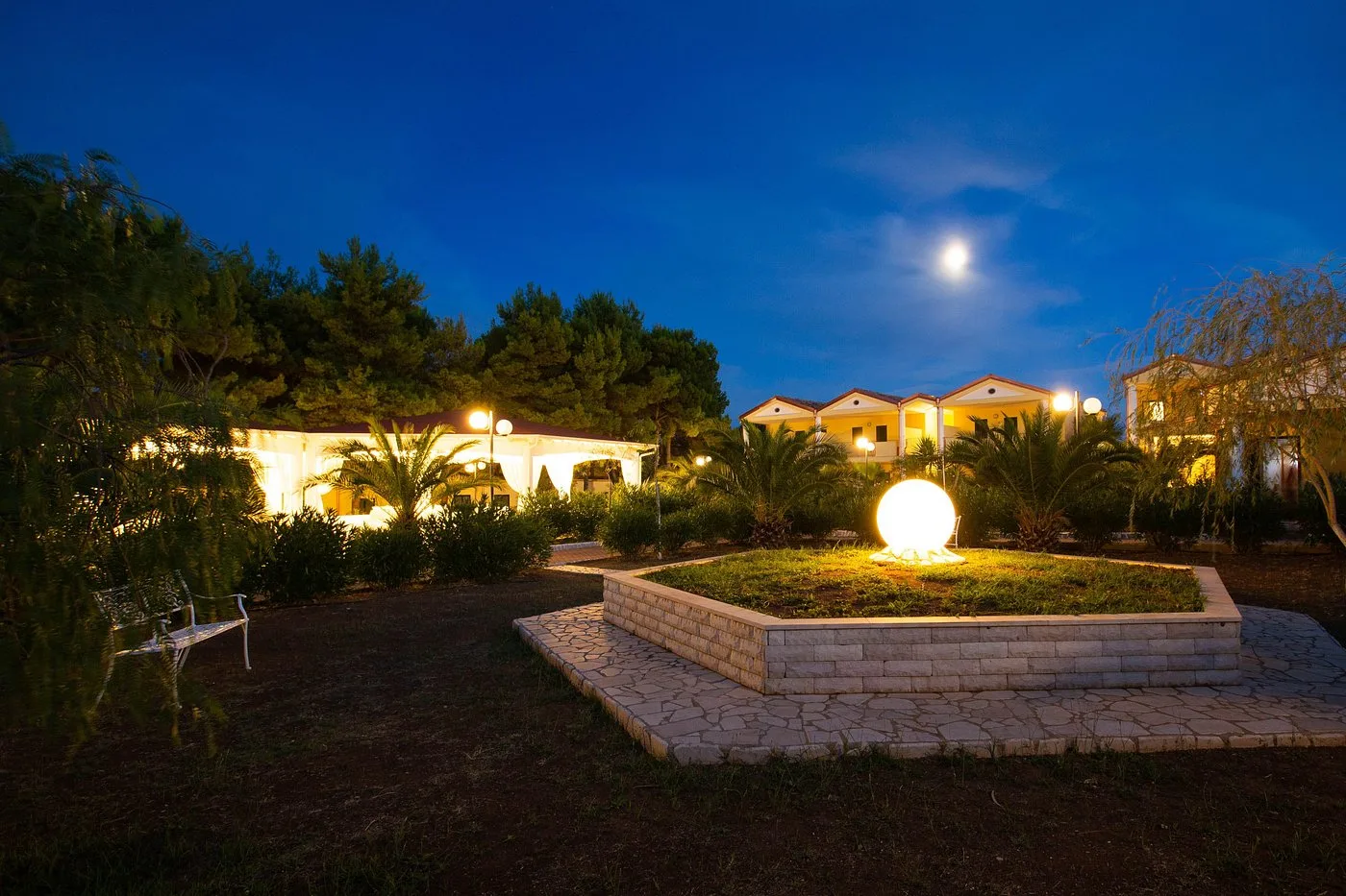 Giardino del villaggio illuminato al crepuscolo con villette e luna
