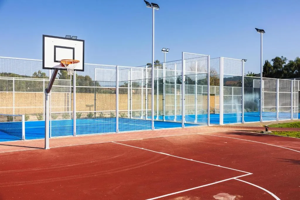 Campo da basket e da padel del resort con illuminazione e recinzione