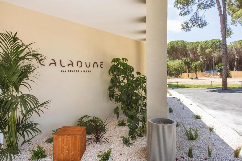 Dettaglio dell'insegna Caladune con piante ornamentali e giardino di ghiaia