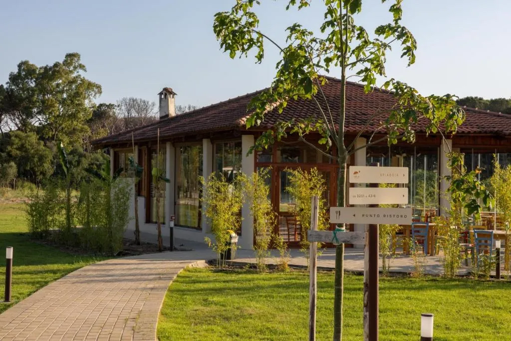 Edificio del punto ristoro con vetrate e giardino curato lungo il vialetto